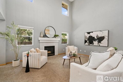 A living room with a fireplace, two couches, and a painting on the wall.