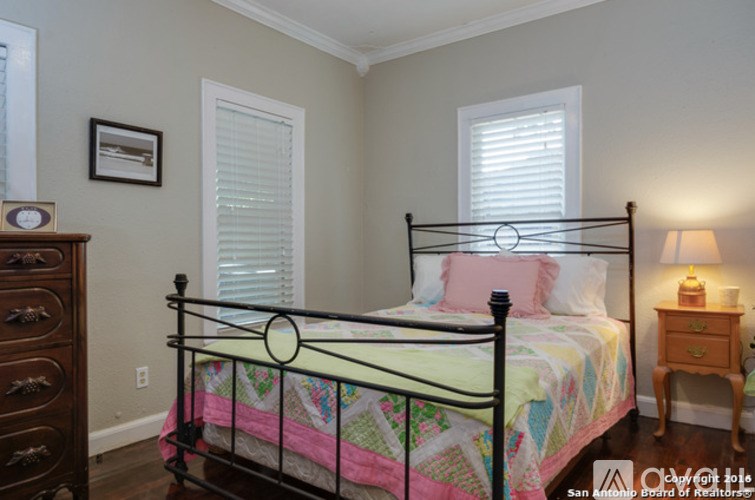 A bedroom with a bed, dresser, and nightstand.