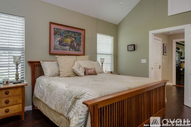 A bedroom with a bed, dresser, and painting on the wall.
