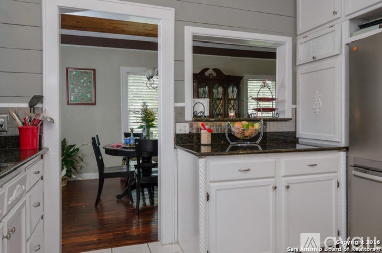 A kitchen with white cabinets and a black table.
