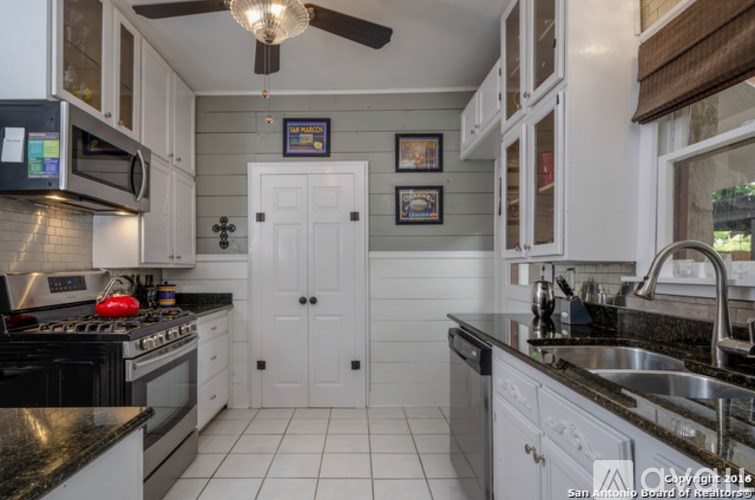 A kitchen with black countertops and white cabinets.