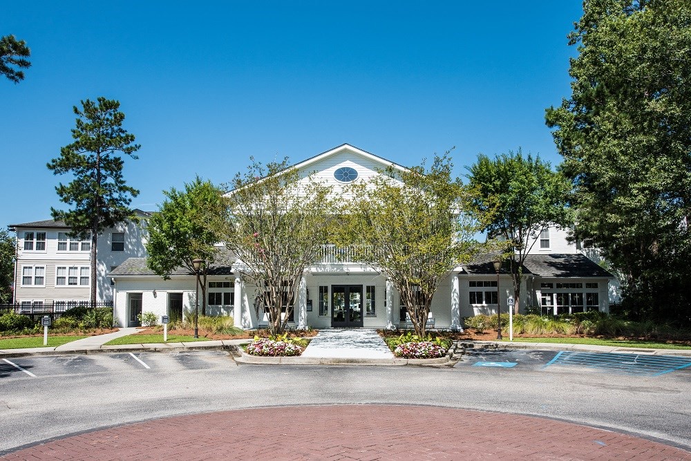 the exterior of a building with trees and a fountain