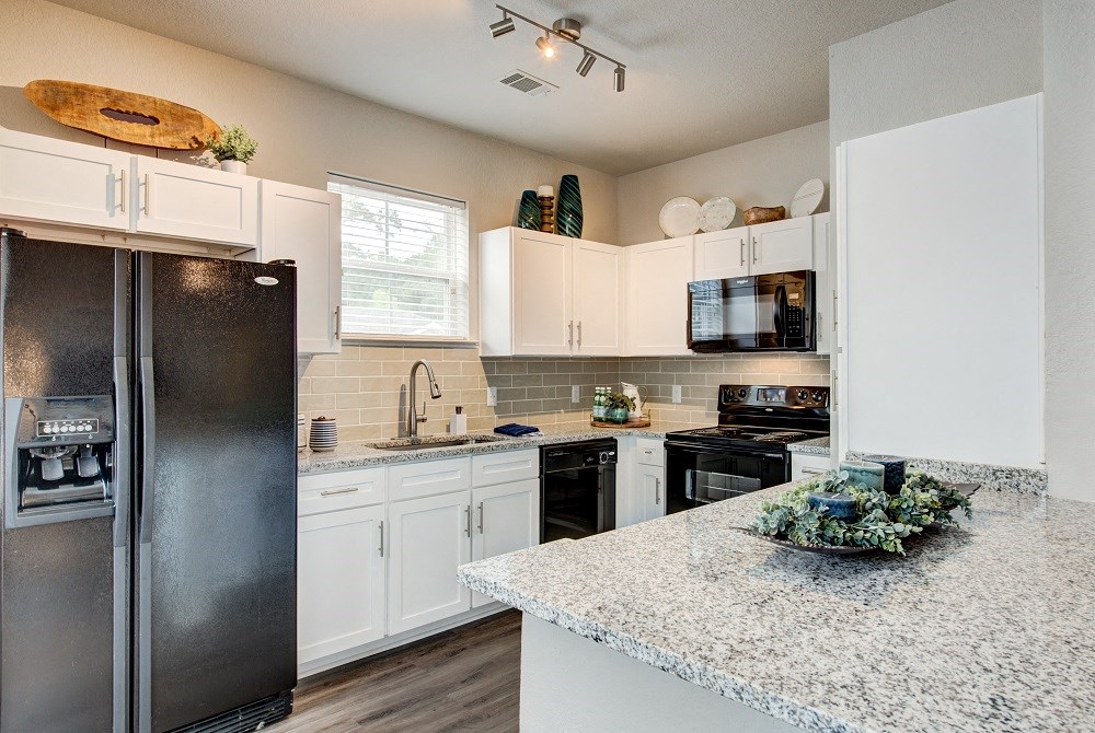 a kitchen with stainless steel appliances and granite counter tops