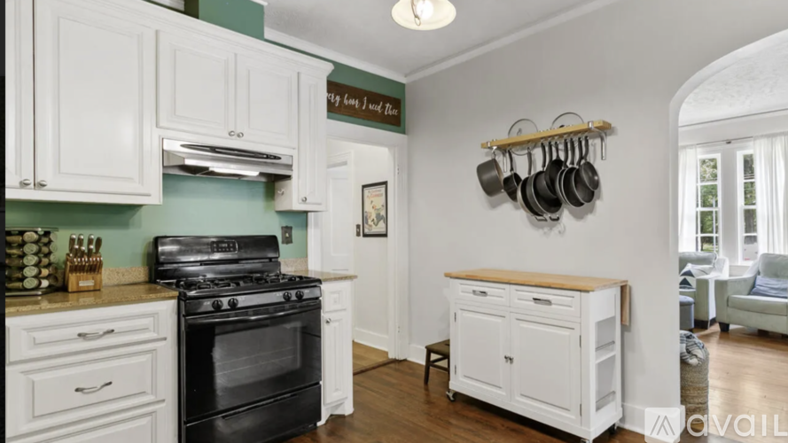 A kitchen with white cabinets and a black stove top oven.