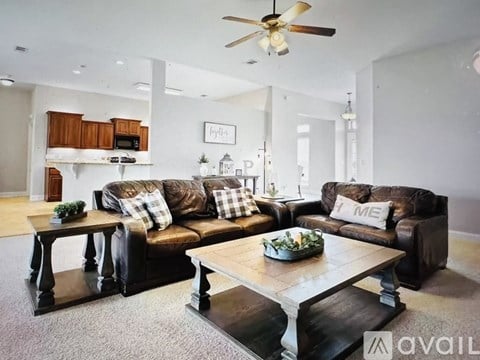 A living room with a brown couch and a wooden coffee table.
