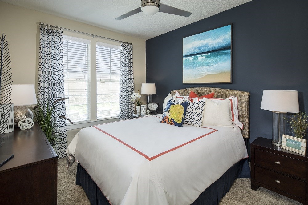 a bedroom with a large bed and a ceiling fan