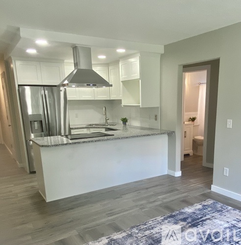 A modern kitchen with a large island and stainless steel appliances.