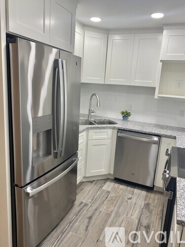 A kitchen with a stainless steel refrigerator and a sink.