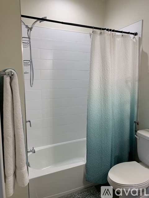 A white towel hangs on a towel rack in a bathroom.