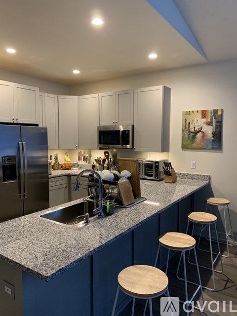 A kitchen with a blue counter and white cabinets.
