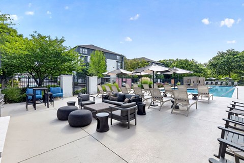 A large outdoor patio area with a pool and lounge chairs.