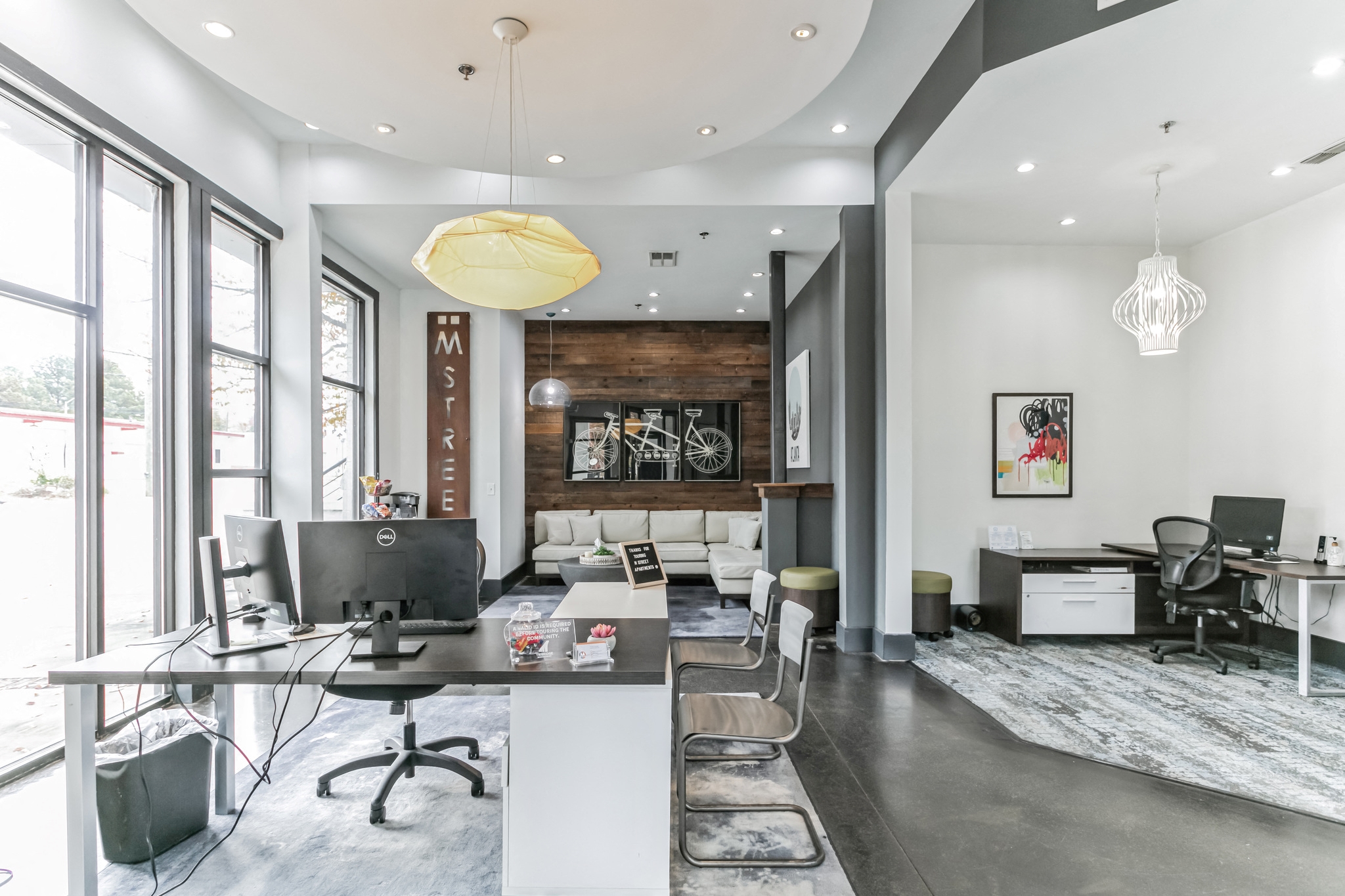 a living room with a large window and a desk with a computer