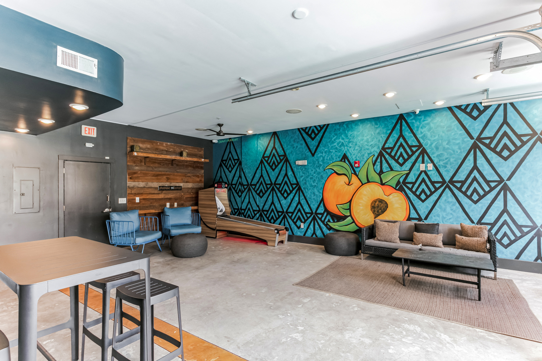 a living room with a couch and a table and a mural on the wall