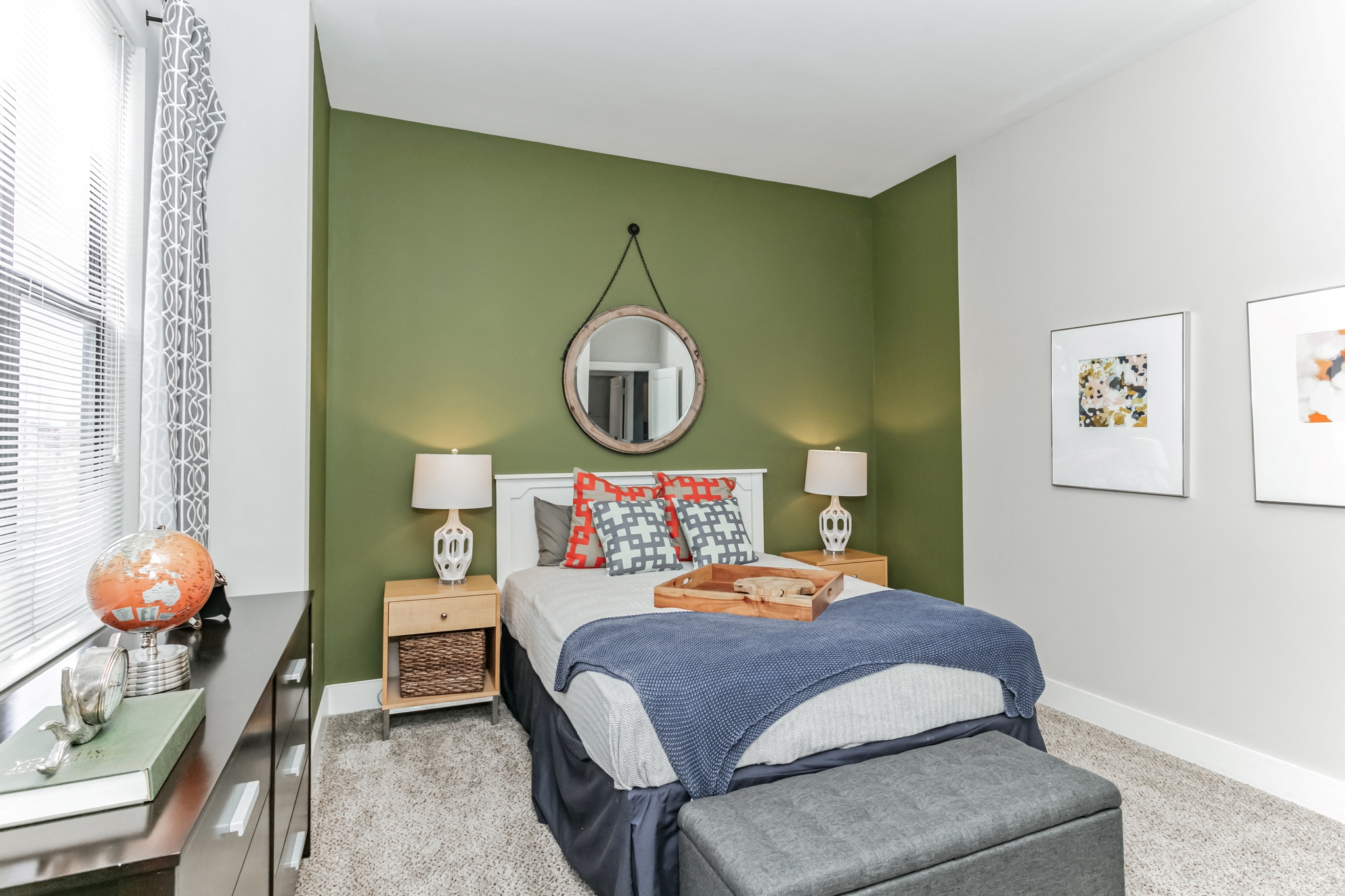 a bedroom with a bed and a green wall and a window
