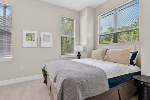 A bedroom with a large bed and two pictures on the wall.