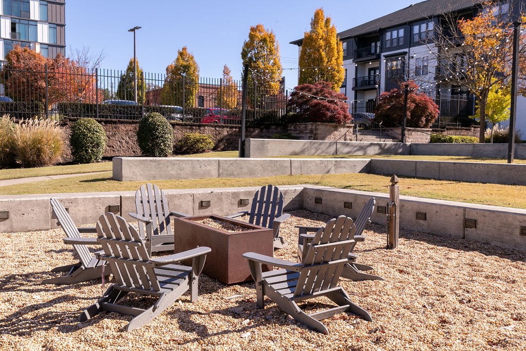 a group of chairs sitting around a fire pit in a park