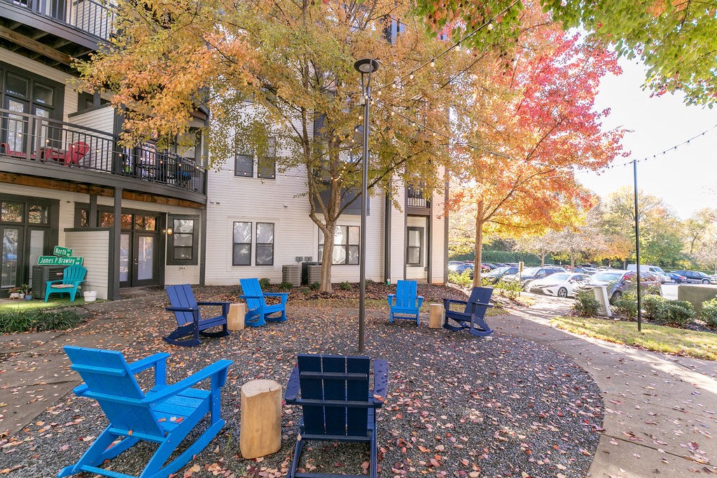 a courtyard with blue chairs and a street lamp in front of a building