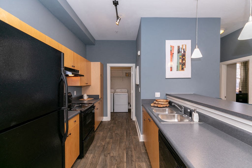 a kitchen with a black refrigerator and a sink