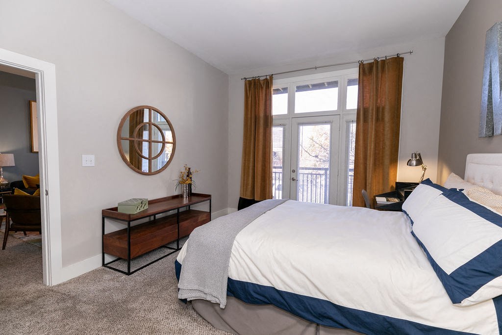 a bedroom with a bed and a door to a balcony