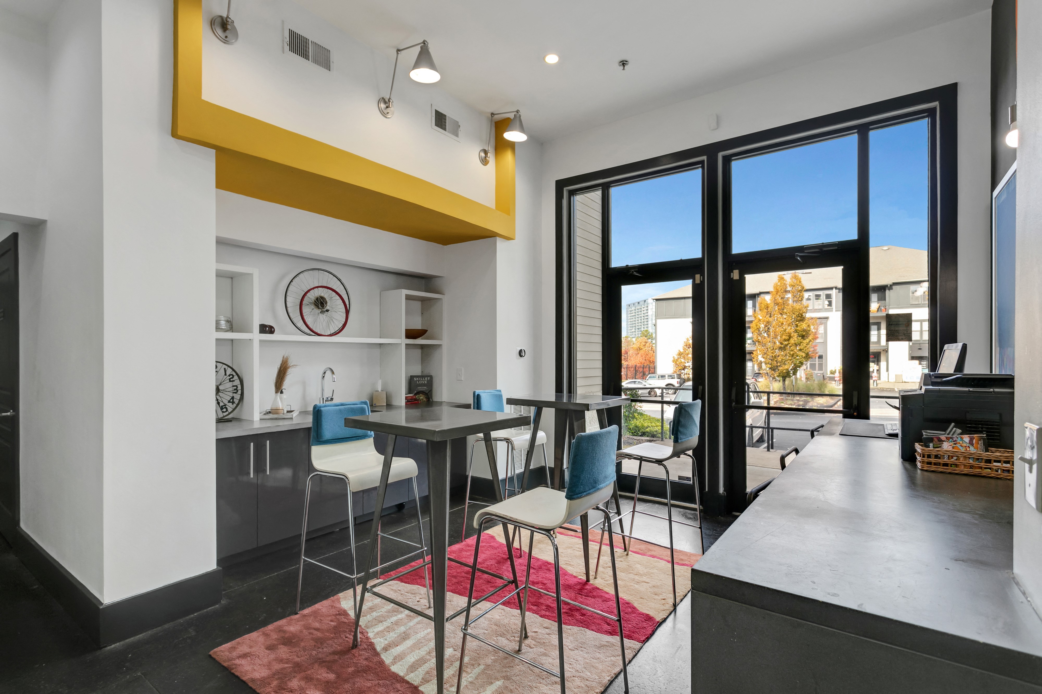 a dining area with a table and chairs and a kitchen with glass doors