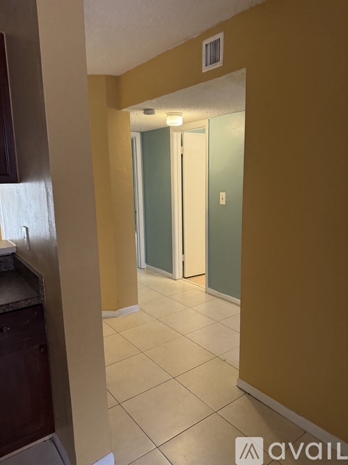 A hallway with a door on the right and a counter on the left.
