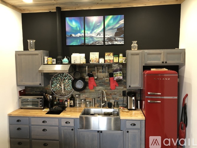 A kitchen with a red fridge and a wooden counter top.