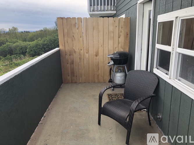 A balcony with a chair and a grill.