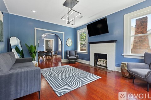A living room with a grey couch and a fireplace.