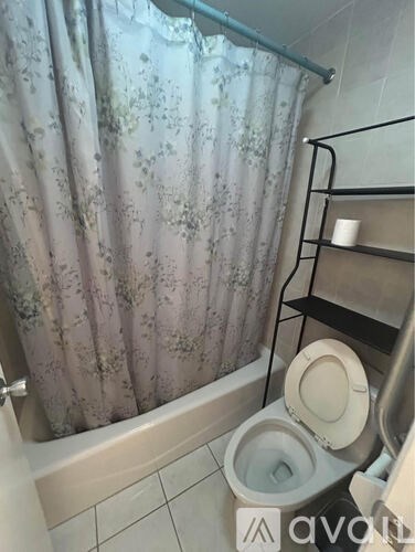 A bathroom with a toilet and a shower curtain.