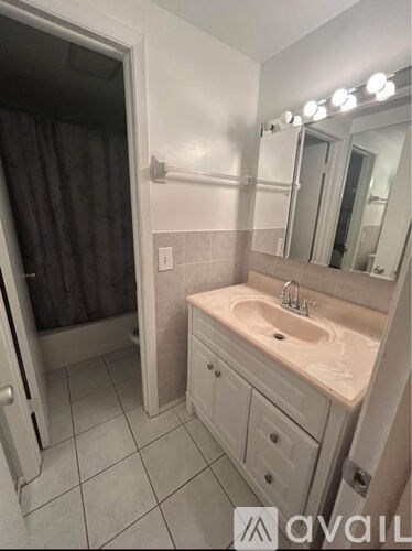 A bathroom with a sink, mirror, and lights.