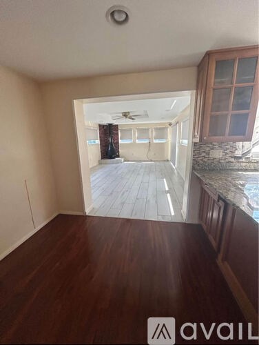 A room with wooden floors and a ceiling fan.