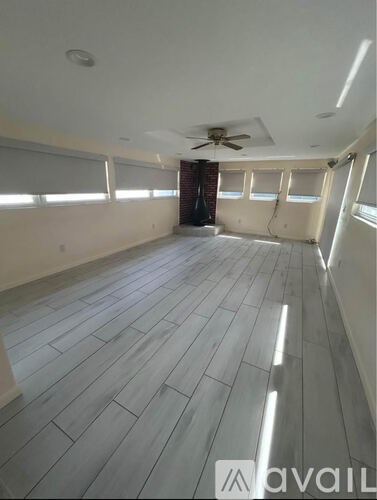 A room with wooden flooring and a ceiling fan.