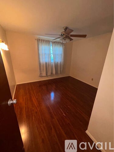 A room with wooden floors and a ceiling fan.