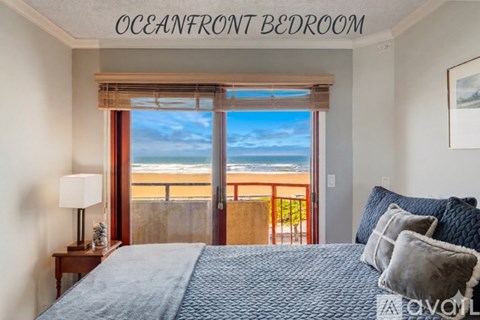 A bedroom with a large bed and a view of the beach.