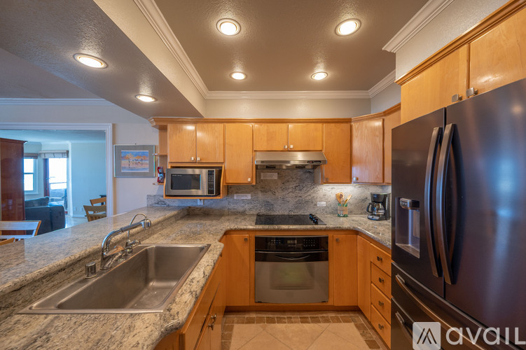 A kitchen with wooden cabinets and a stainless steel refrigerator.