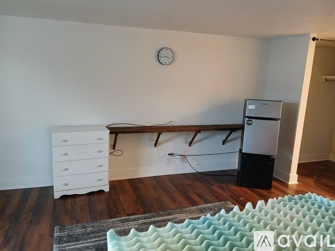 A room with a white dresser and a black speaker.