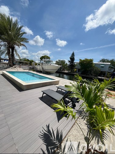 A swimming pool with a concrete edge and a blue water feature in the middle.