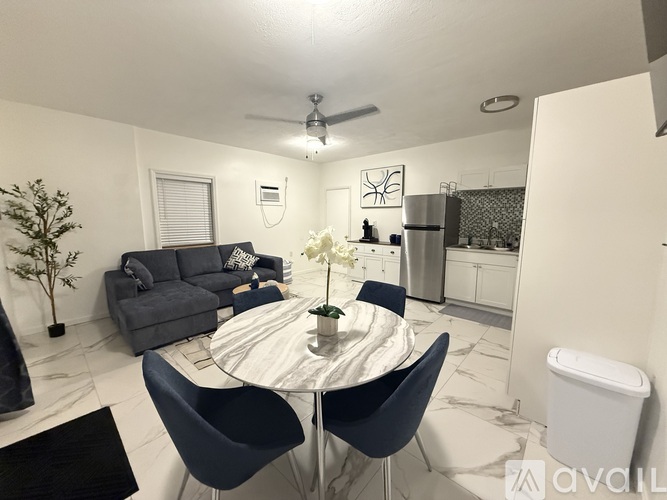A modern dining room with a round table and chairs.