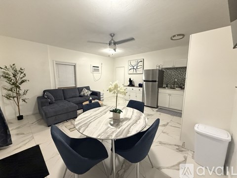 A modern dining room with a round table and chairs.