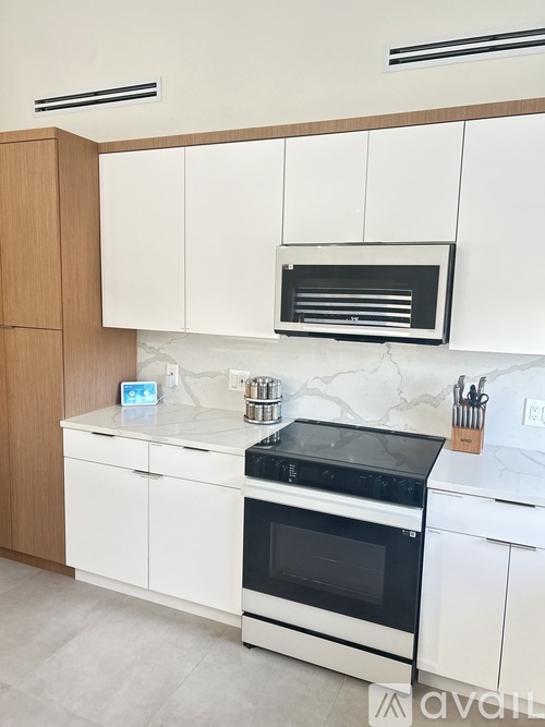 A kitchen with white cabinets and a black stove top.