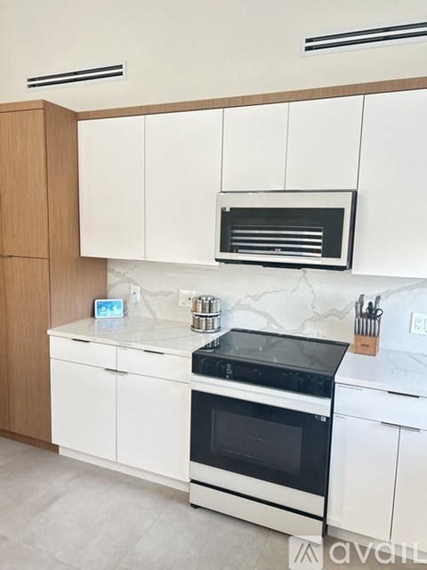 A kitchen with white cabinets and a black stove top.