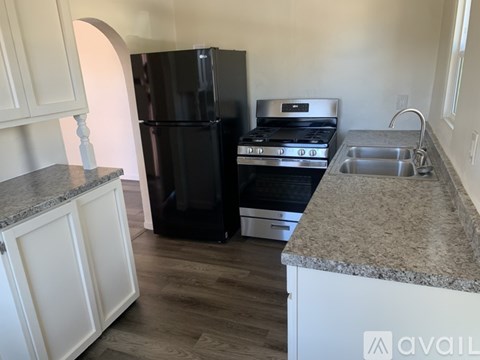 A kitchen with a black fridge, stove, and oven.