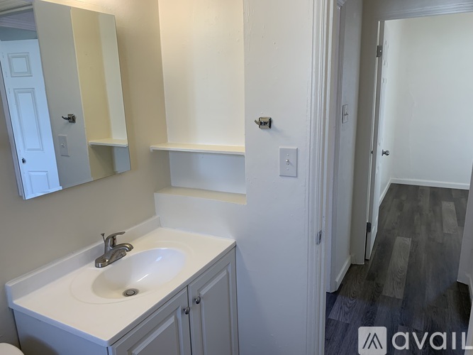 A bathroom with a sink, mirror, and cabinets.