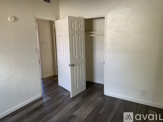A room with a white door and wooden flooring.