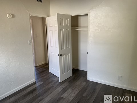 A room with a white door and wooden flooring.