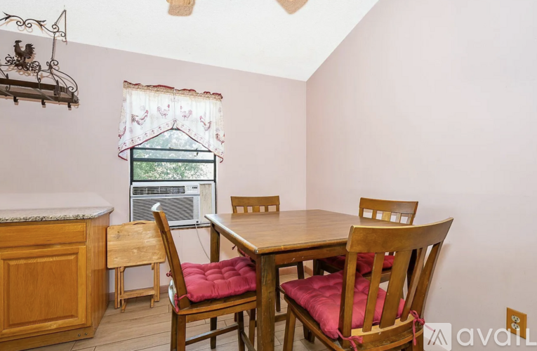 A dining room with a table and chairs.