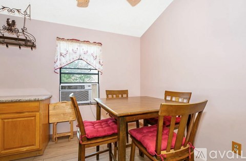 A dining room with a table and chairs.