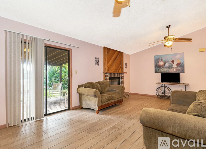 A living room with a fireplace, a bicycle, and a painting of a rabbit.