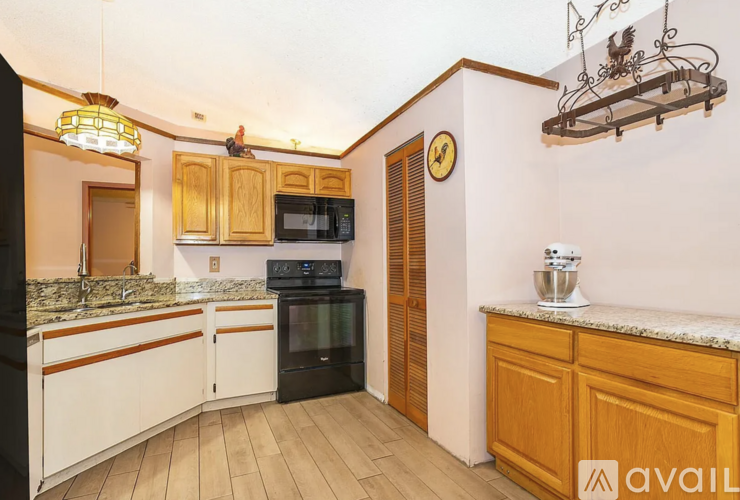 A kitchen with wooden cabinets and a black oven.