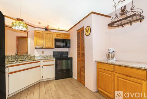 A kitchen with wooden cabinets and a black oven.
